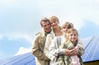 Family posing together in front of solar panels in Munich, Bavaria, Germany