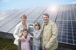 Foto: Happy family standing in front of solar paneling, Munich, Germany Happy family standing in front of solar paneling, Munich, Germany