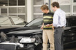 Insurance adjuster assessing damage to car