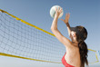 Junge Frau spielt Volleyball am Strand