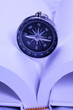 Open White book with a magnetic compass