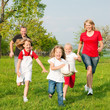 Familie spielt Ball auf einer Wiese
