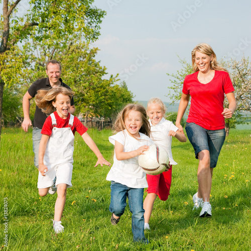 Photo: Familie spielt Ball auf einer Wiese Familie spielt Ball auf einer Wiese