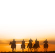 horse riders at sunset