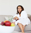 Young woman in bath robe on the sofa