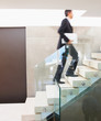 Blur motion: Business man walking up a flight of stairs