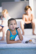 Girl eating chocolate donut at the poolside