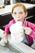 Portrait of a girl blowing soap suds in a measuring jug