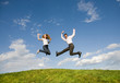 Happy smiling couple jumping in blue sky Happy smiling couple jumping in blue sky