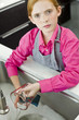 Portrait of a girl washing a measuring jug at a sink