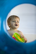 Baby boy playing with a toy viewed through an inflatable ring