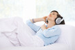 Woman is listen to the music on couch