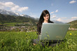 Foto: Mädchen mit Laptop in Wiese / Hintergrund Schladming Mädchen mit Laptop in Wiese / Hintergrund Schladming