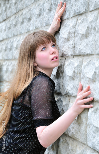 Photo: Blue-eyed long-haired girl leans on elbow wall and looks up Blue-eyed long-haired girl leans on elbow wall and looks up