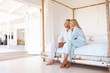 Loving senior couple sitting on the bed, looking away