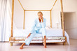 Portrait of a happy pretty blond sitting on a bed