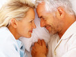 Closeup of a romantic mature couple holding hands on bed