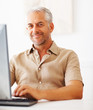 A senior retired happy man with a laptop