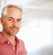 An aged man smiling on a blur background