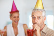 Elderly man having drink at a birthday party