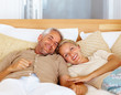 Charming mature couple sleeping on the bed
