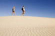 Hikers March Across Desert Sand Dune