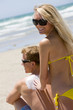 A woman rubbing sunscreen on her boyfriend
