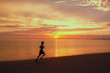 coureur sur la plage au couché du soleil