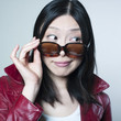 femme curieuse regardant par dessus ses lunettes de soleil