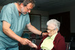 Photo: Male nurse giving pills to a senior woman Male nurse giving pills to a senior woman