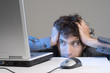 Man biting desk while looking at computer screen