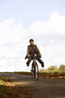 A young woman riding a bicycle downhill