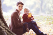 A young mother sitting in the grass with her baby on her knee