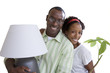 Photo: Woman with pot plant embracing husband, man carrying lamp, smiling, portrait, cut out Woman with pot plant embracing husband, man carrying lamp, smiling, portrait, cut out