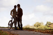 A young couple standing with a bicycle in autumn time