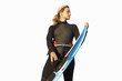woman in wetsuit holding surfboard, cut out