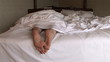Woman lying in bed and stretching her feet