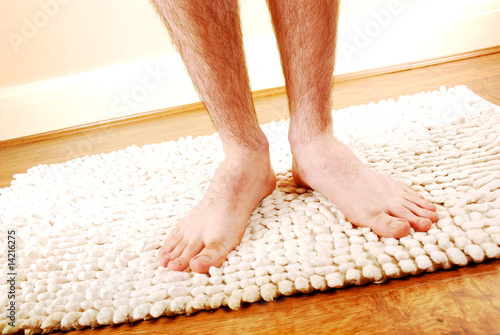Photo: Man's legs on a bathmat Man's legs on a bathmat