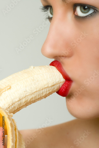 Photo: closeup of a woman biting a bannana closeup of a woman biting a bannana