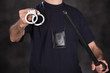 Photo: Handcuffs and stick in male officer's hand Handcuffs and stick in male officer's hand