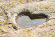 stone granite heart with puddle and moss