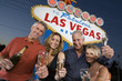 Photo: Two women and two men posing in front of Welcome to Las Vegas sign, group portrait. Two women and two men posing in front of Welcome to Las Vegas sign, group portrait.