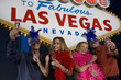 Photo: Two women and two men posing in front of Welcome to Las Vegas sign, group portrait Two women and two men posing in front of Welcome to Las Vegas sign, group portrait