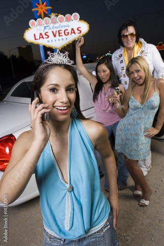 Photo: Portrait of young woman, two women with Elvis impersonator in background, Las Vegas, Nevada, USA Portrait of young woman, two women with Elvis impersonator in background, Las Vegas, Nevada, USA
