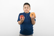 Pre-teen 10-12 boy holding doughnut and apple