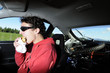 Man driving car while eating from bag