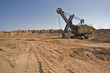Rusty old yellow excavator on a sand