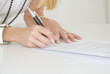 Femme signant un document Femme signant un document
