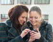 Young girls watch something in mobile phone