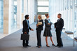 Image of business associates standing in discussion at the hallw